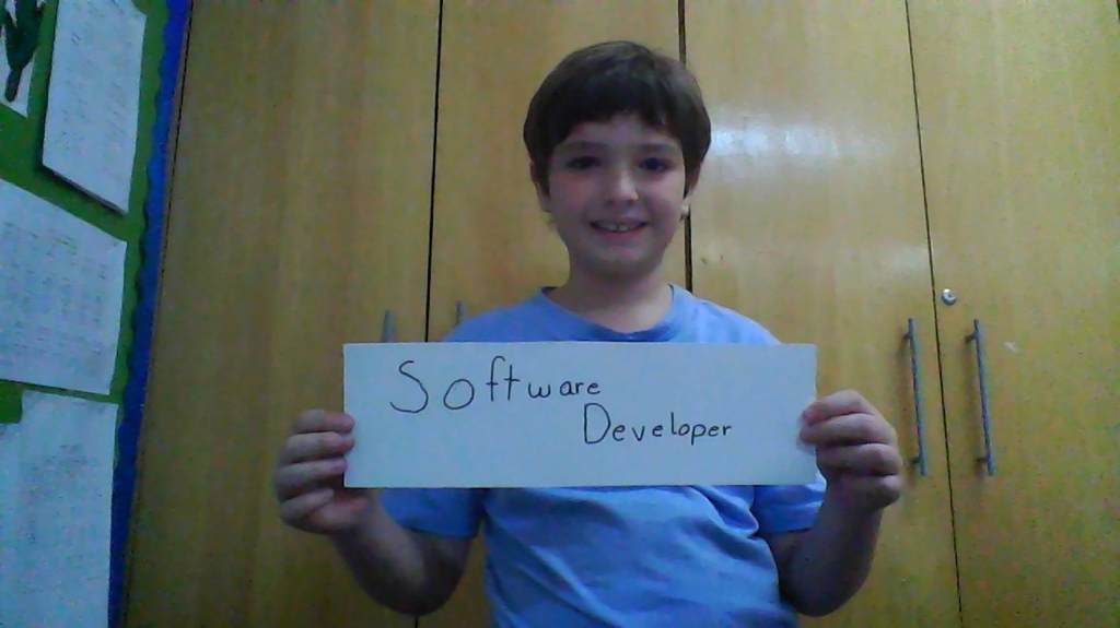 Photograph of Diogo at 8 years old holding a sign that says Software Developer